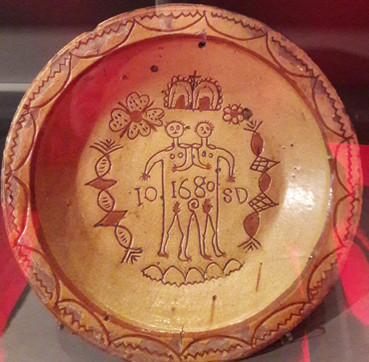 red plate with a crude line drawing of conjoined twins marked with the date 1680