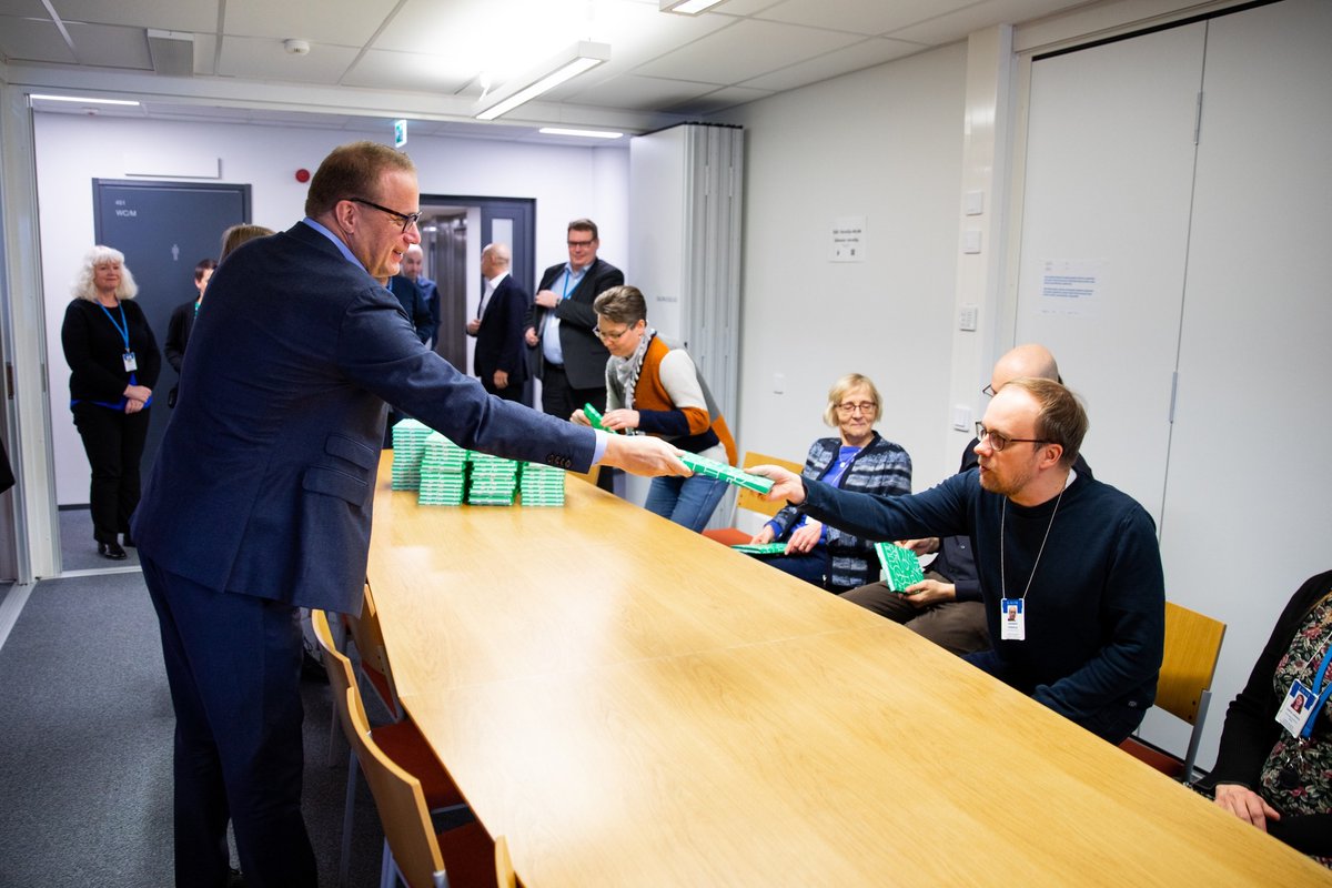 Lahden kaupungin henkilöstö sai oman muistikirjan viestinnän tueksi. Kaupunginjohtaja ojentaa muistikirjan toiselle henkilölle. 