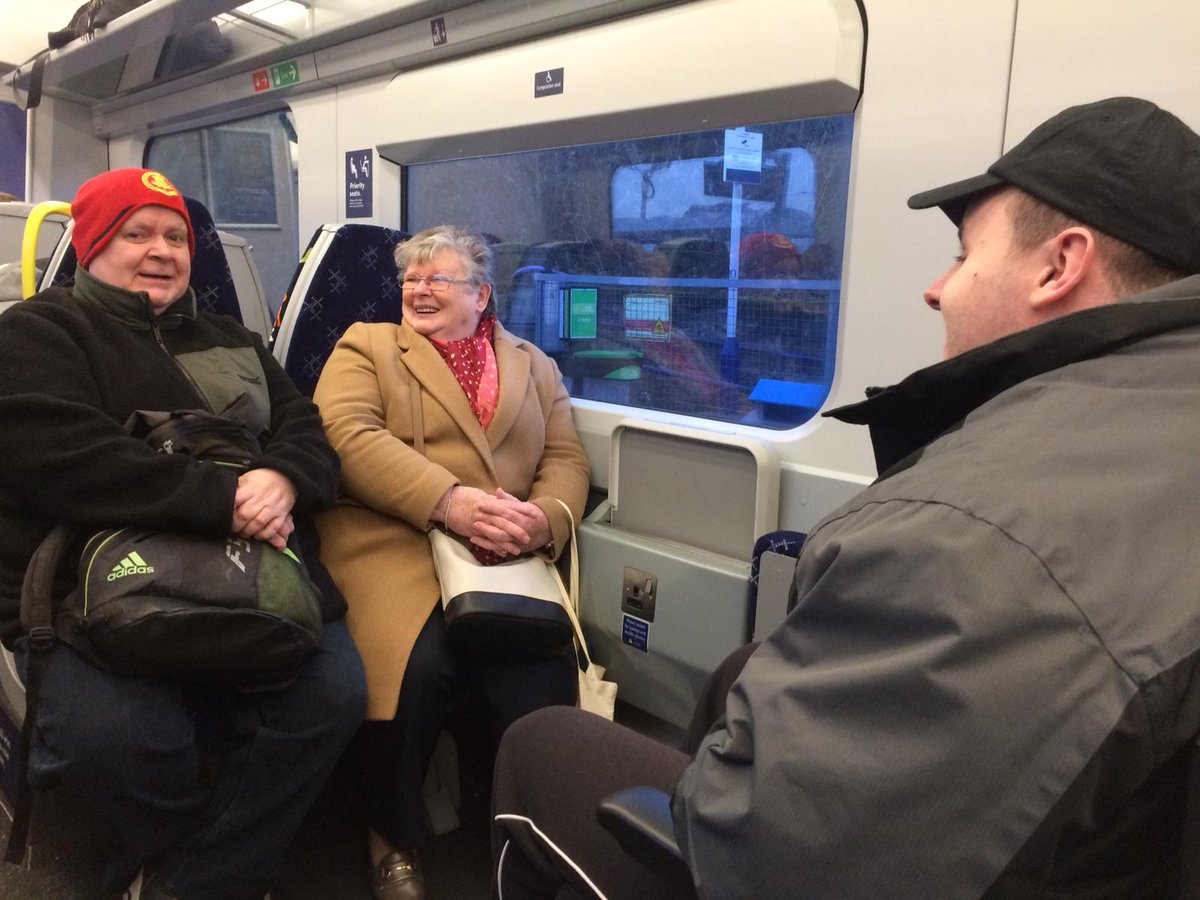 Three members laugh on the train back from Edinburgh.