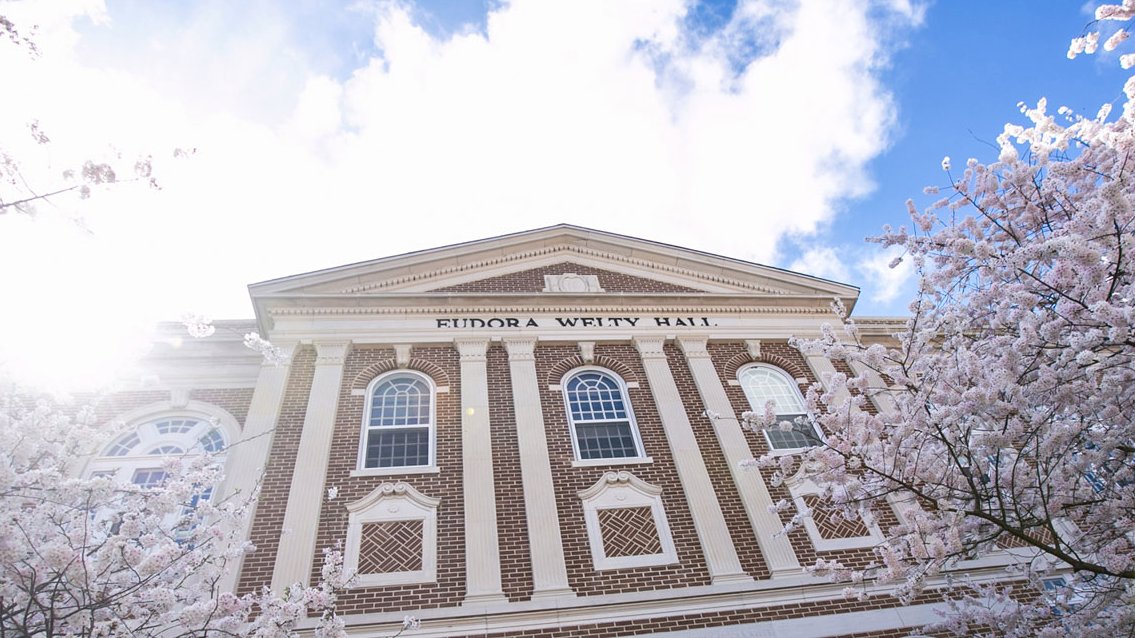 Eudora Welty Hall at MUW with blooming trees in front.