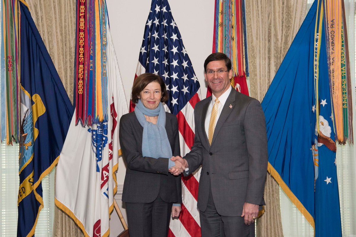 Secretary Esper and French Minister of the Armed Force Florence Parly shake hands in front of flags, in an indoor meeting, at the Pentagon.