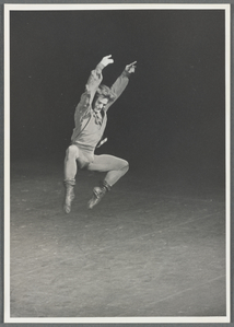 male ballet dancer jumping arms up legs turned out and knees bent.