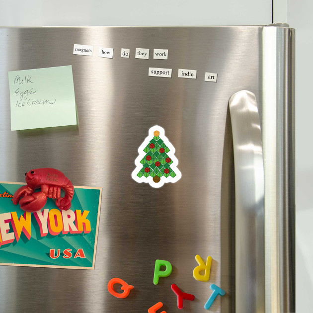 A picture of a refrigerator with a magnet on it. The magnet is in the shape of a Christmas tree and is made up of the shapes of table top role playing game dice.
