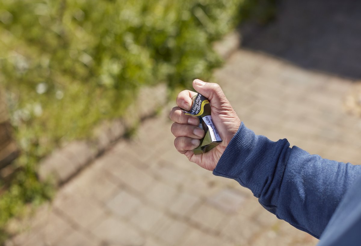 hand scrunching up a cigarette packet