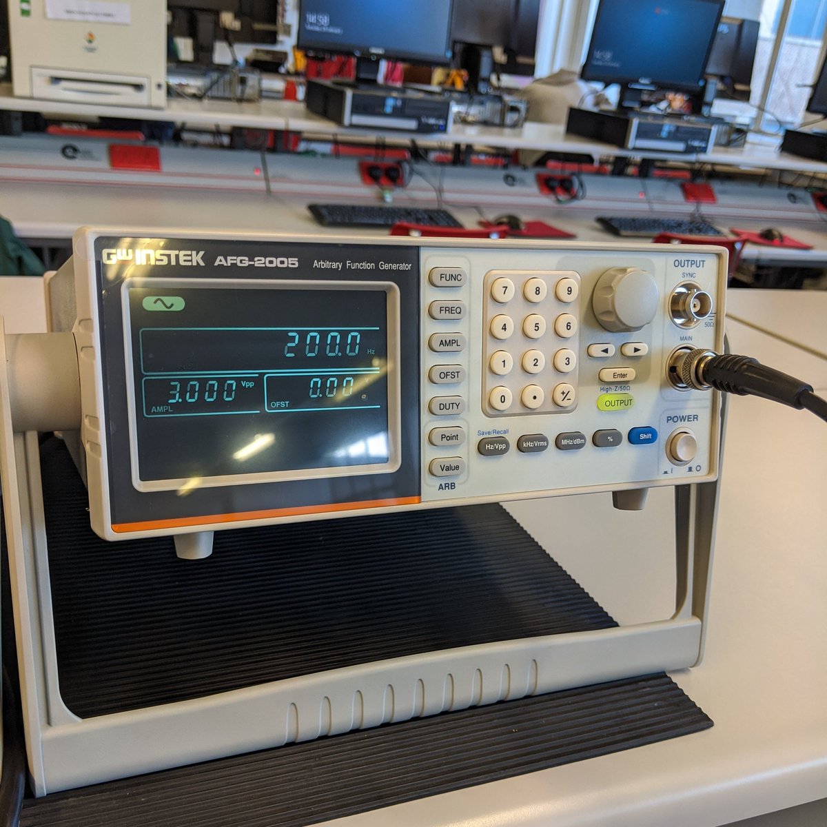 A signal generator, with dials, numbers and various buttons for controlling the output of the box. There's also a black screen for reading out the frequency and amplitude of the signal. Currently it's set at 200 Hz and 3 V