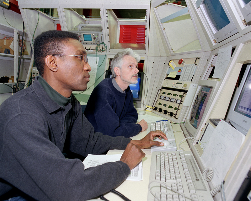 Two people working at the controls of the accelerator.