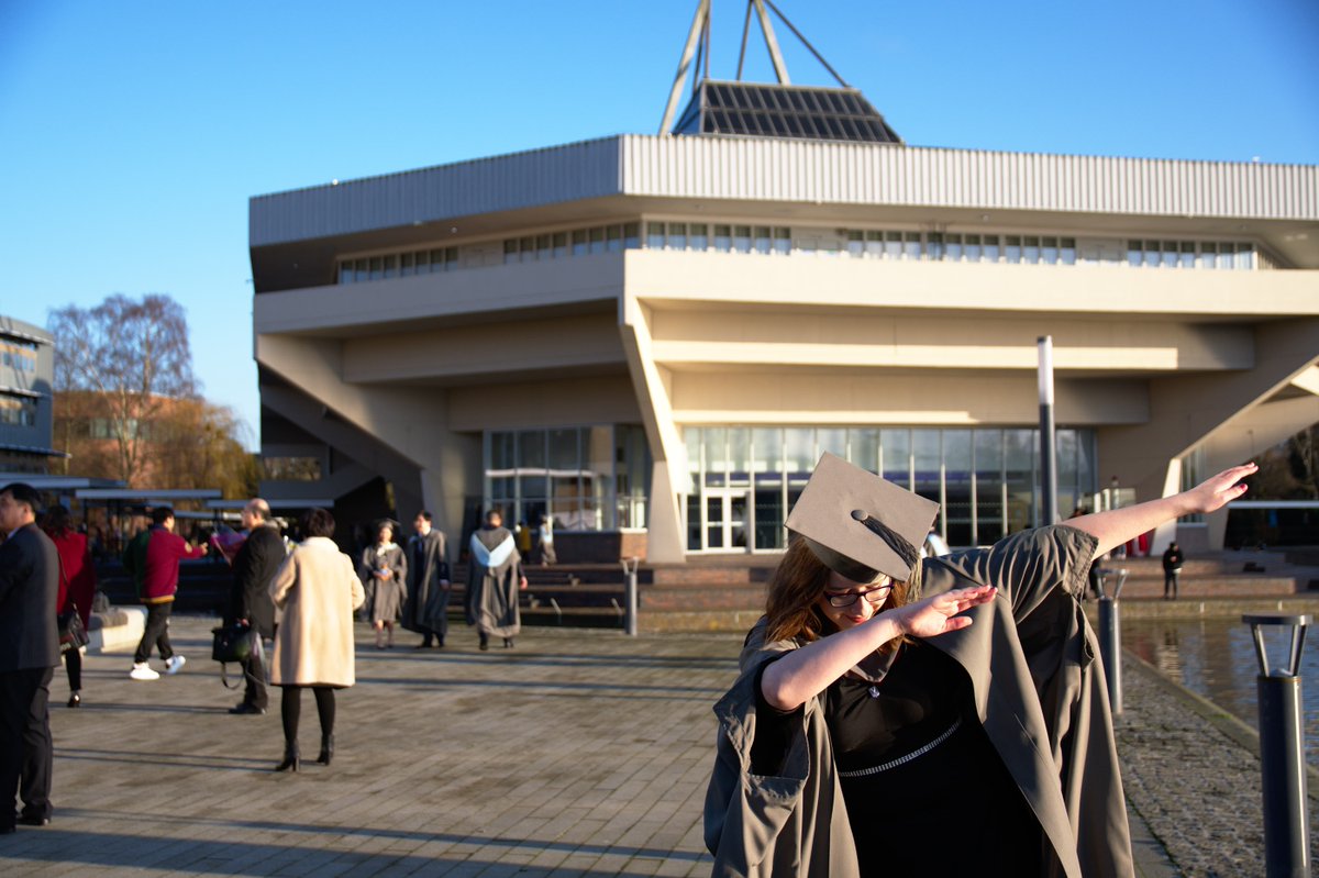 Rach dabbing in her graduation gown in front of Central Hall