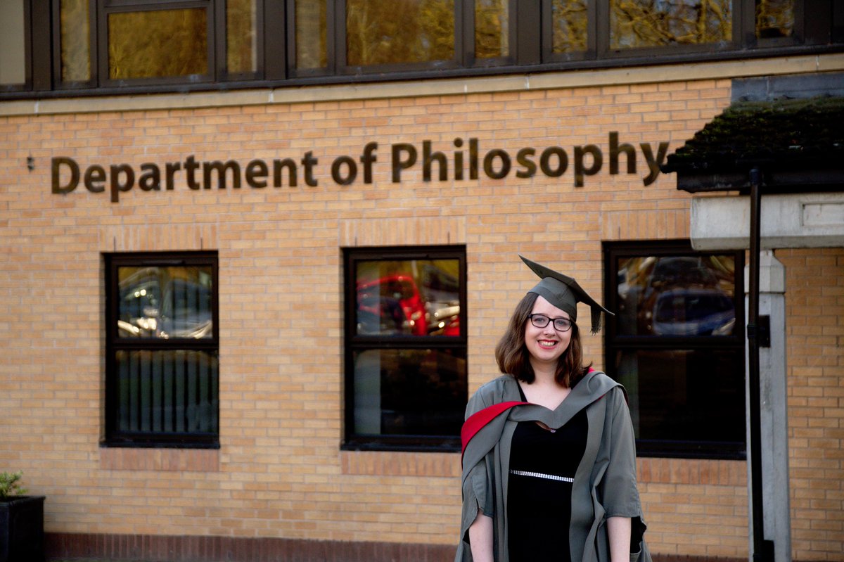 Rach in her graduation gown in front of the Philosophy department