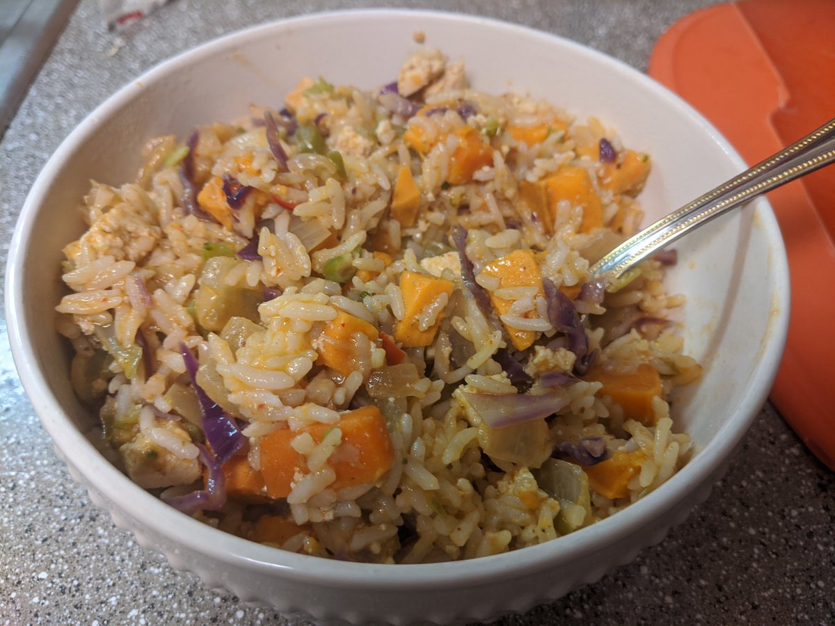 Close up shot of the curry in a bowl. You can see all of the chopped up ingredients mixed in with the rice. Steam is rising off of it.