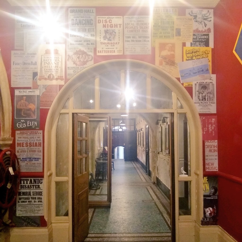 Hall doorway arch surrounded by red wall and vintage posters for events