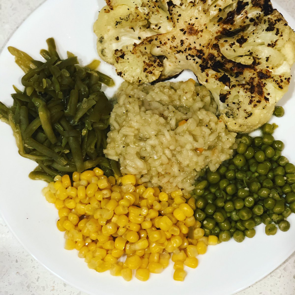 HealthHeld's tweet photo. Funny thing. When I finished making this for my wife, someone tried stealing my hot grill. Anyways. Grilled her cauliflower steaks served with French cut garlic green beans, garlic risotto, peas and yellow corn. 

#HealthHeldinHand https://t.co/KA9nulrjWe