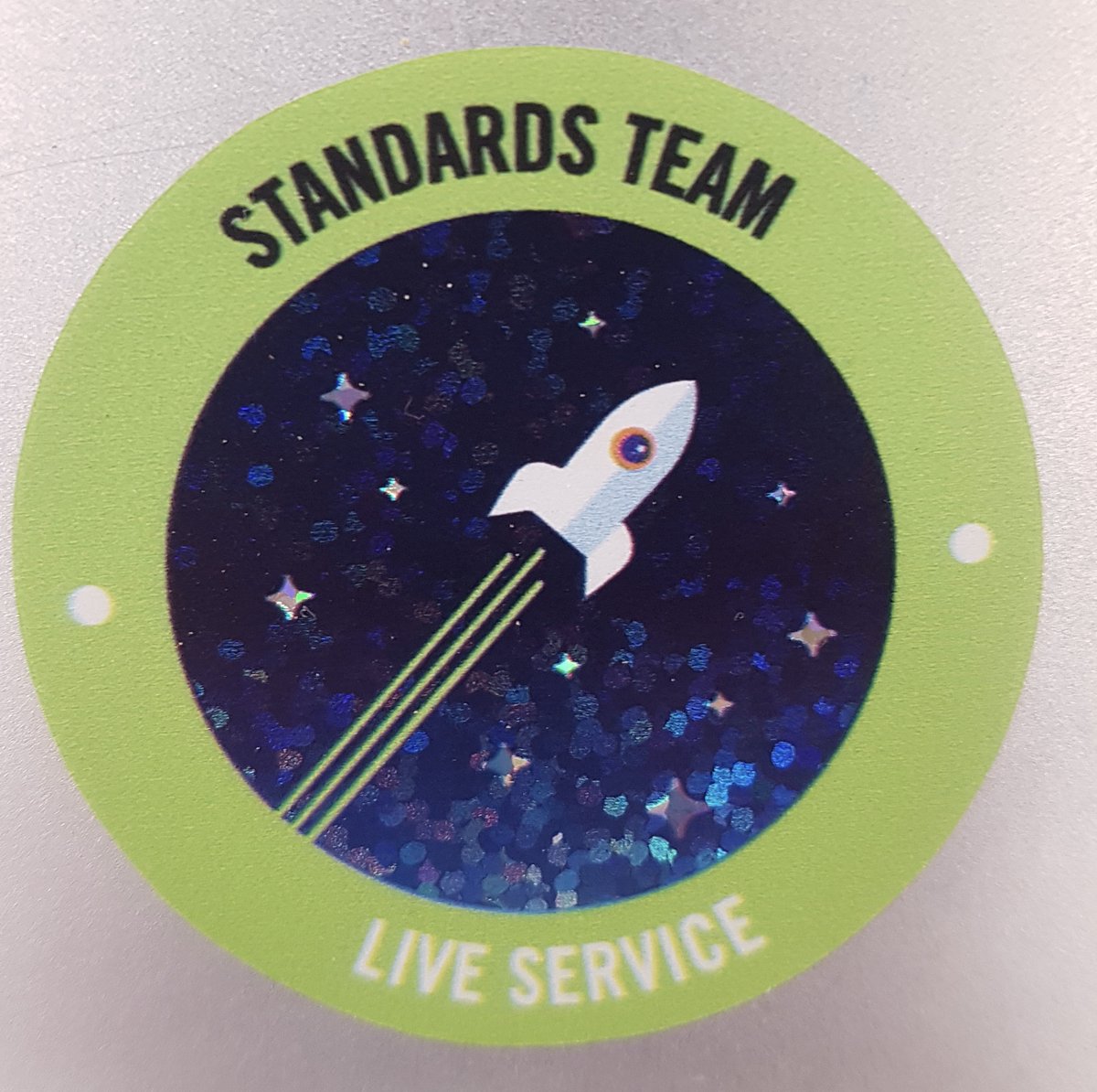 Green sticker with rocket says standards team live service
