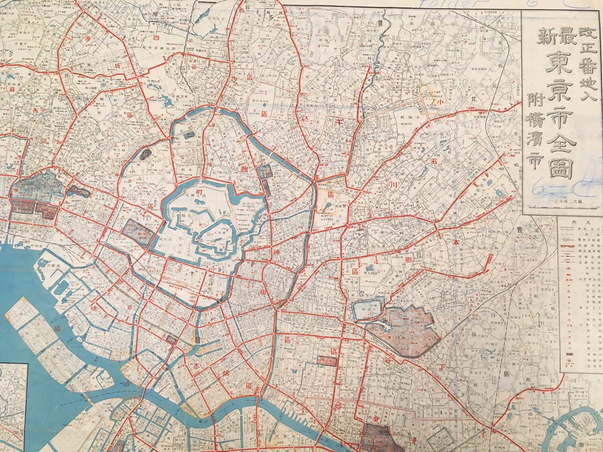 Japanese street map of Tokyo with the rings of major roads in red, the bay to the left, and many details and labels for areas and buildings