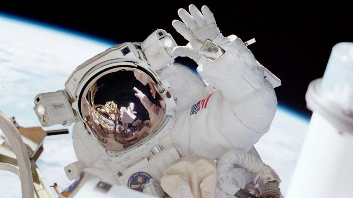 Photograph of a NASA astronaut waving in space