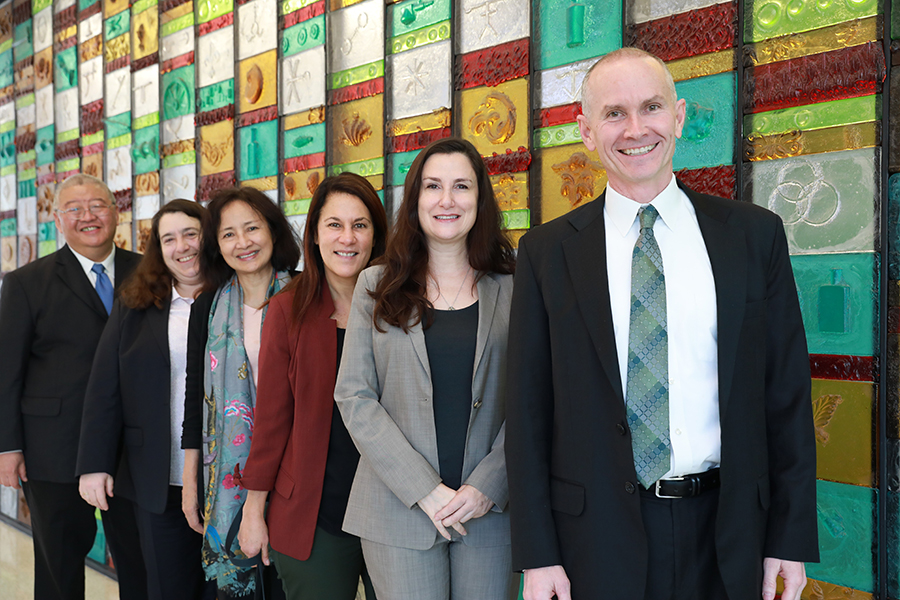 group photo of people smiling with a colorful background