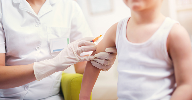 A child getting a vaccine administered by a nurse.