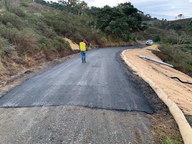 Two men walking on newly paved road