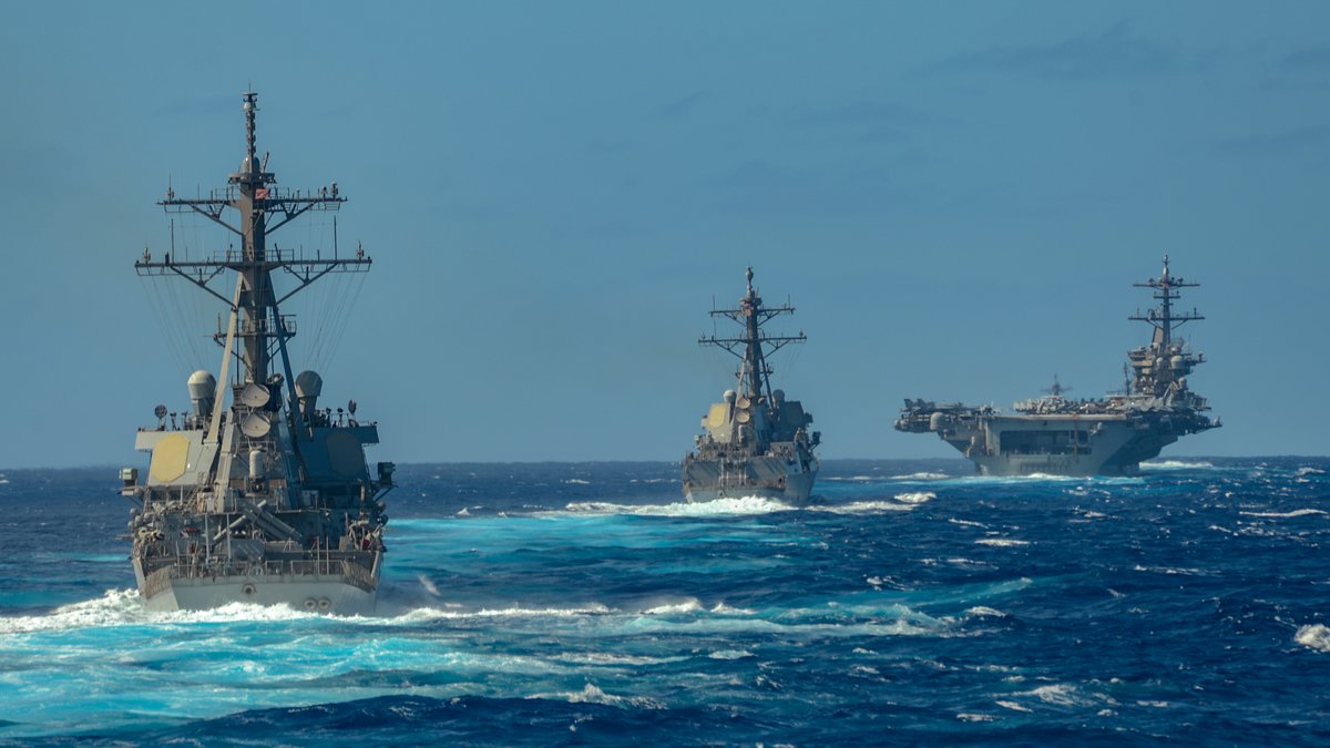 Three U.S. ships of the Theodore Roosevelt Carrier Strike Group sail on the Pacific Ocean.
