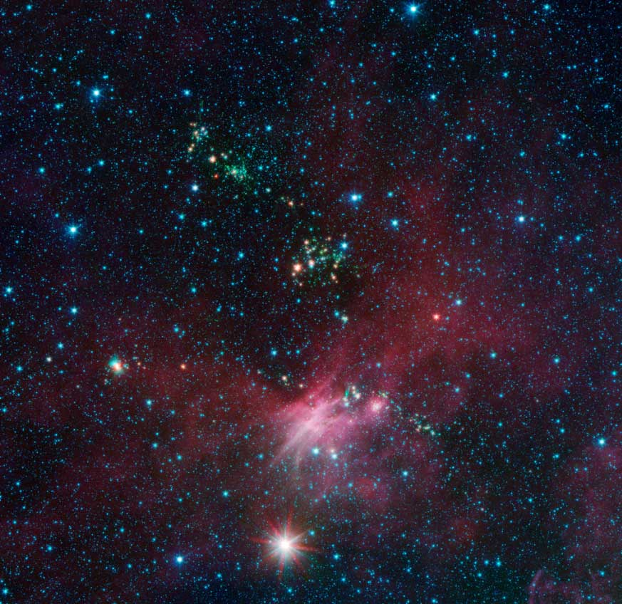 Stars and jets are seen against the black of space as bright blue, white and green dots amid a red haze.
