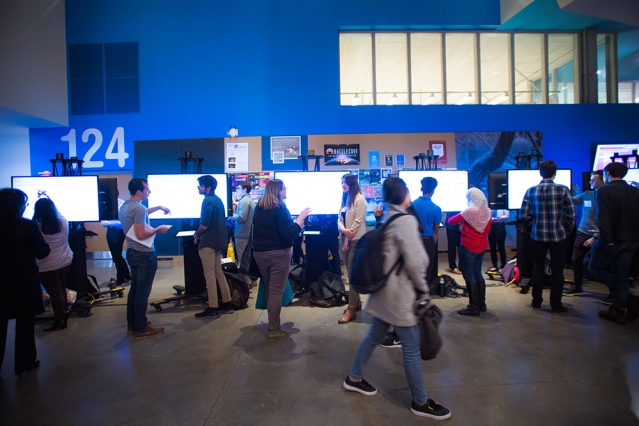 group of students and listeners in front of video posters