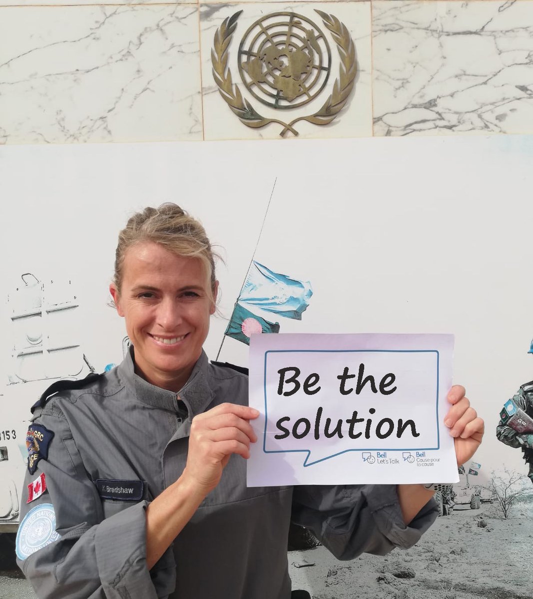 A Canadian police officer in Bamako, Mali, as part of the United Nations Multidimensional Integrated Stabilization Mission in Mali (MINUSMA), celebrating #BellLetsTalk Day. She is holding a sign saying "Be the solution".