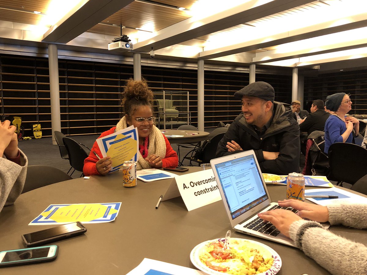 Two people at table smiling and talking