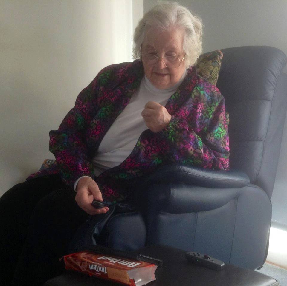 Grandmother playing the Nintendo Switch with Tim Tams propping up the Switch