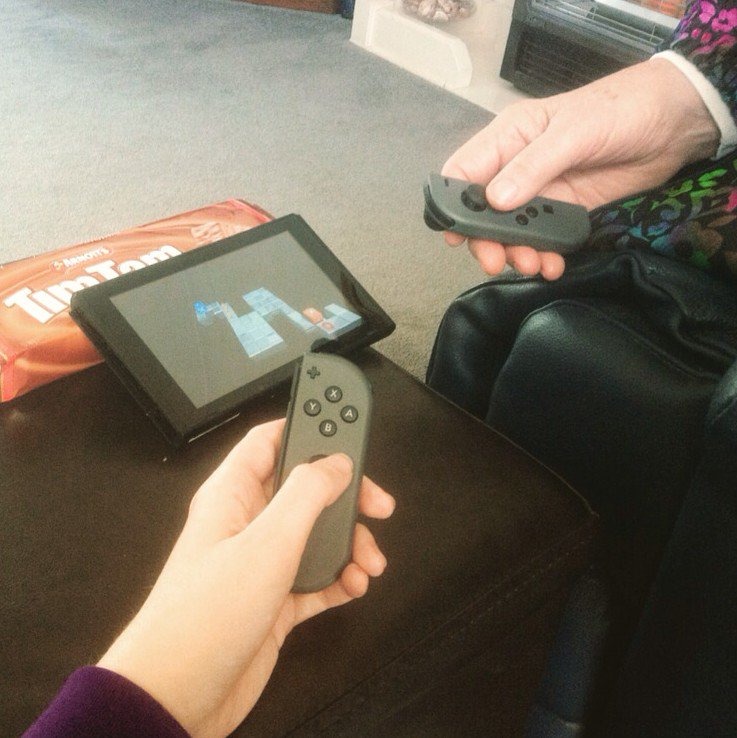 Close up of grandma's hand and grand daughters playing switch