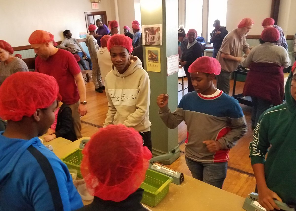 youth and adults together wearing hair nets packaging at first presbyterian