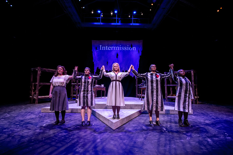 Performers hold up hands at intermission of "Two Remain"