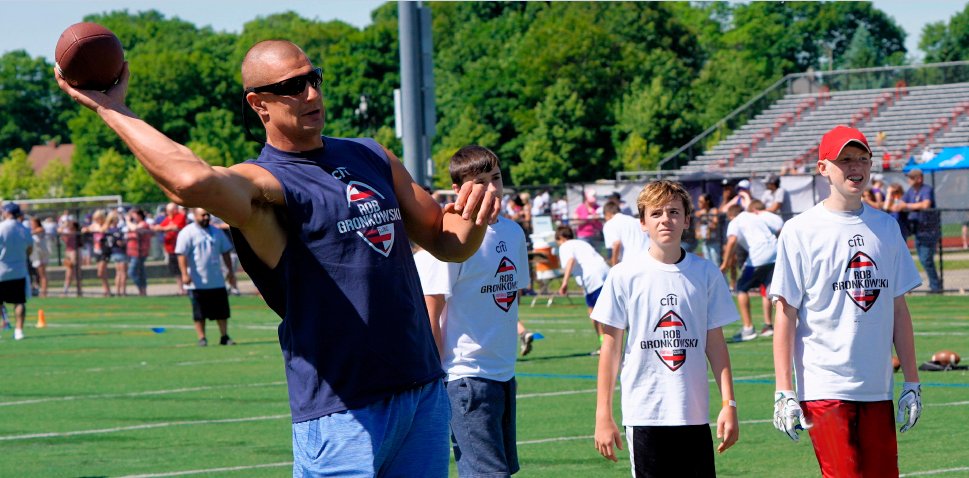 Image of Rob Gronkowski throwing a football at his youth football clinic