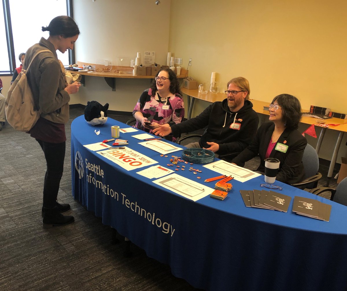 Seattle IT staff greet a City employee at an information table.