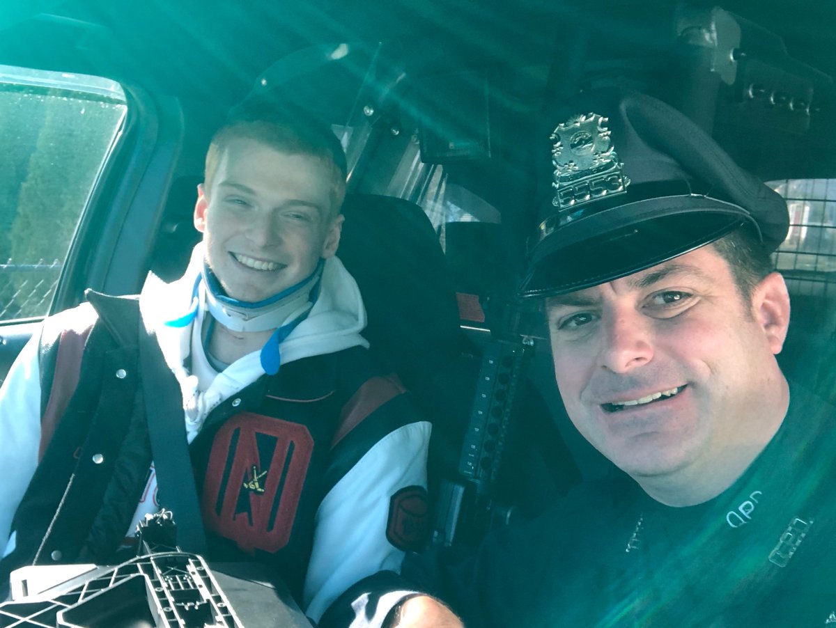 connor sitting in police cruiser with officer hartnett