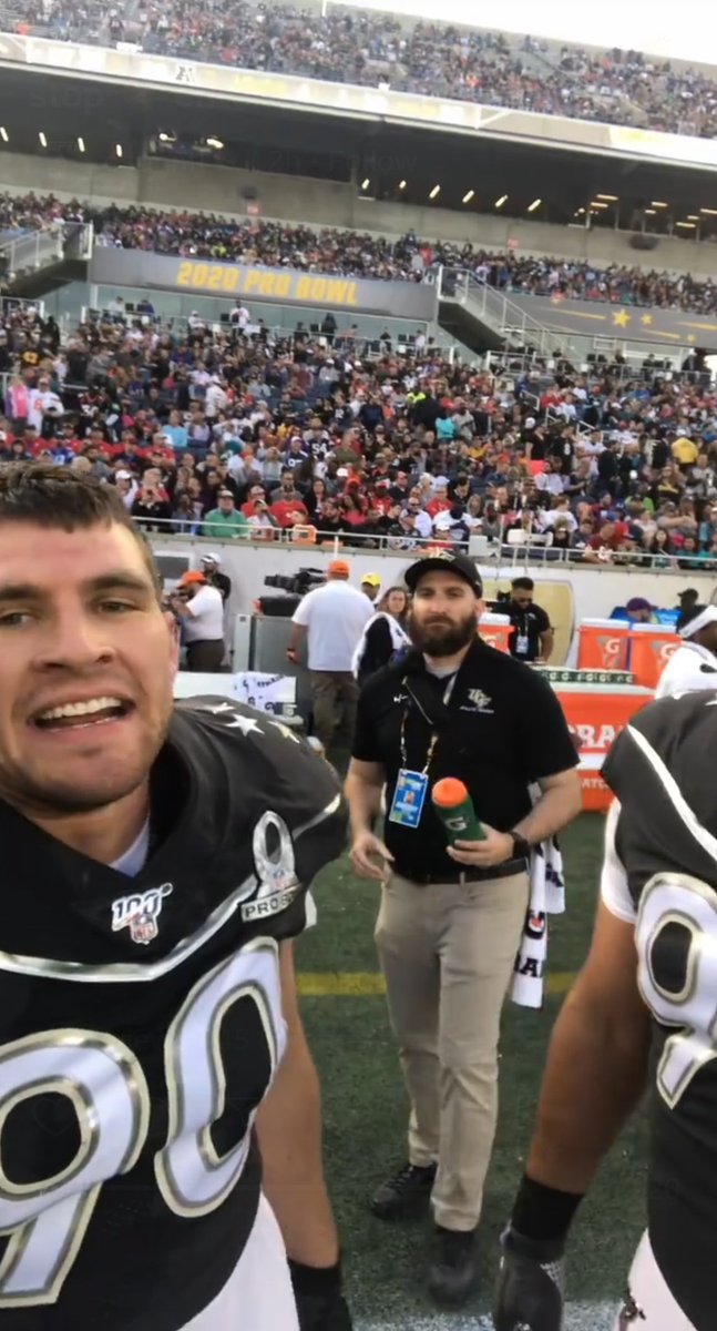 A man bringing a football player water.
