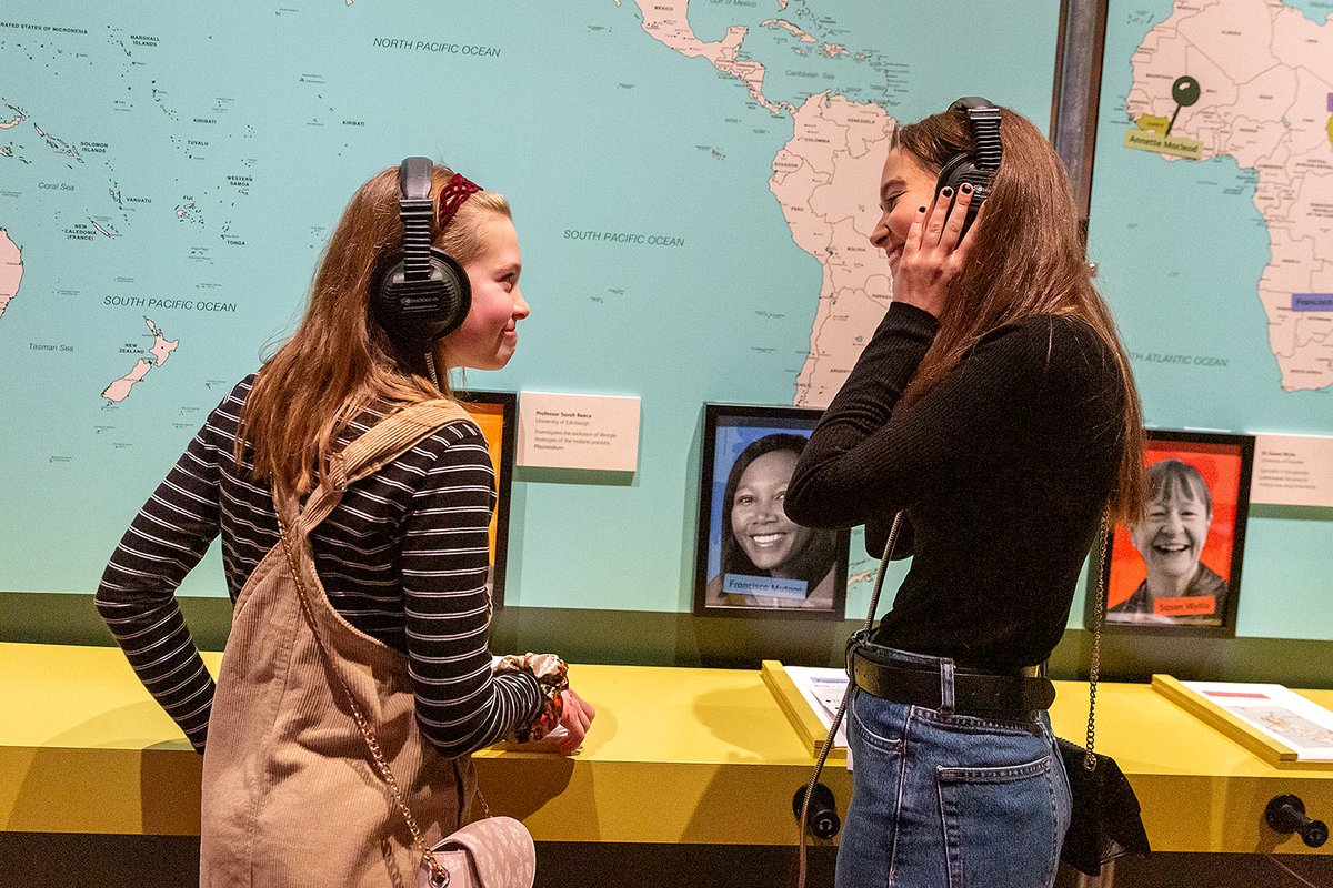 Two girls with headphones in exhibition