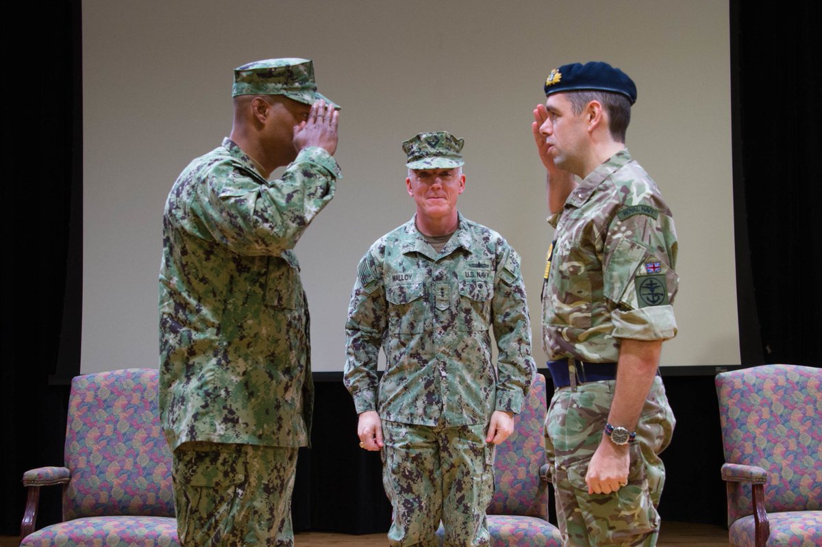 U.S. Navy Rear Adm. Alvin Holsey salutes the incoming IMSC commander, Royal Navy Commodore James Parkin, during the change of command ceremony.
