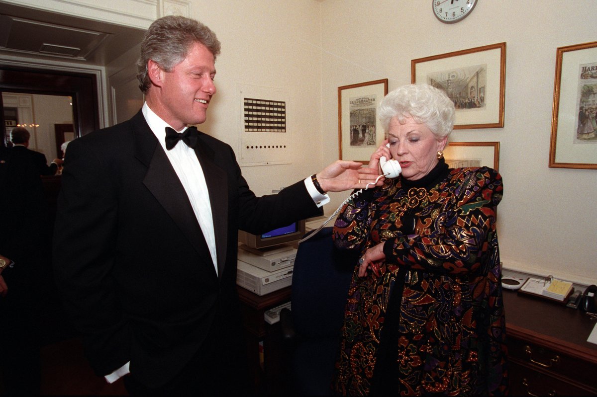 President Clinton holds the telephone up to Texas Governor Ann Richards' ear to say hello. 