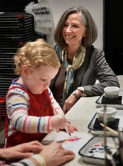 Two-year-old Elizabeth Woods paints in the expanded Martin ArtQuest at the Frist Art Museum as her mom, Molly, talks with Frist CEO Dr. Susan Edwards  (Photo: Larry McCormack / The Tennessean)