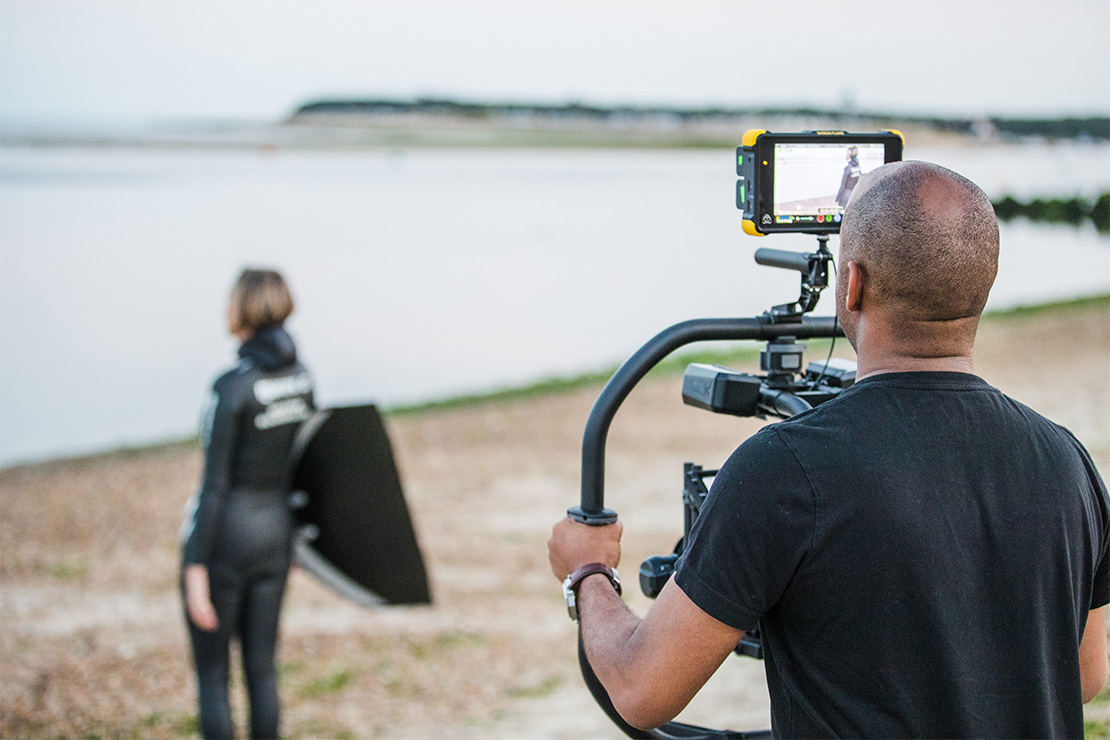 Simeon Quarrie filming on a beach. 