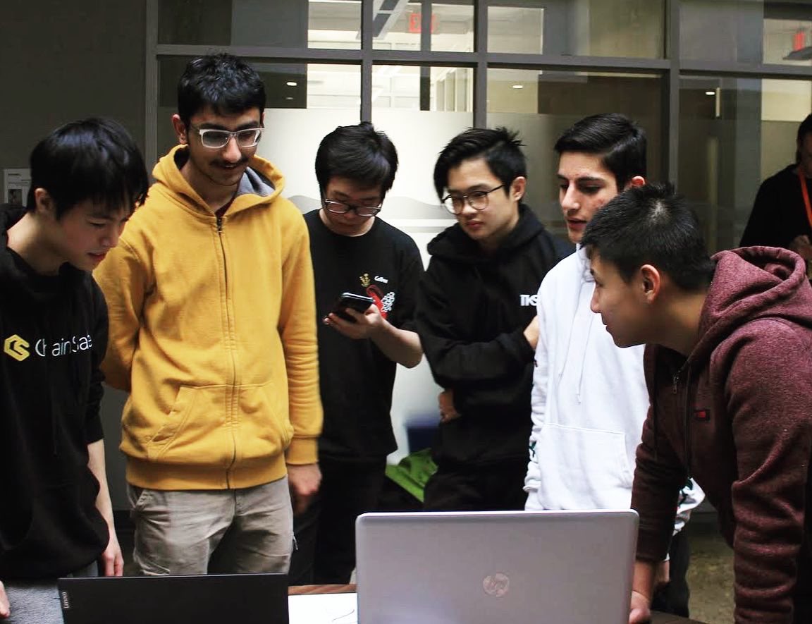 Group of 6 youth gathering to look at a laptop