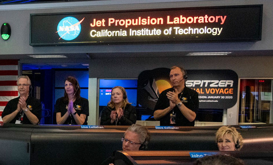 Thomas Zurbuchen stands in JPL mission control with others during spitzer's end of mission.