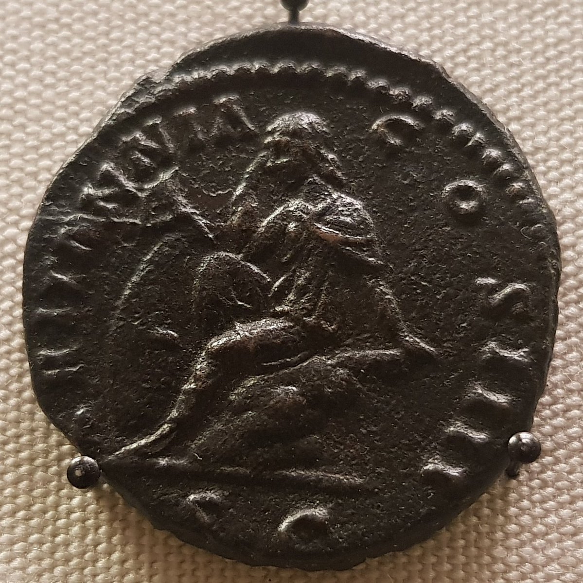 The reverse of an 'as' (low denomination Roman coin), showing a seated female figure, head resting on one hand, with a shield by her side. To the left is her name, Britannia
