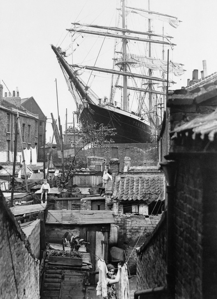 When it comes to the juxtaposition of the magnificent amongst the squalid, this photo has it all - what an utterly amazing view from the slum gardens of Millwall - the 3-masted barque 'S.V. Penang' in dry dock at the Isle of Dogs in 1932
