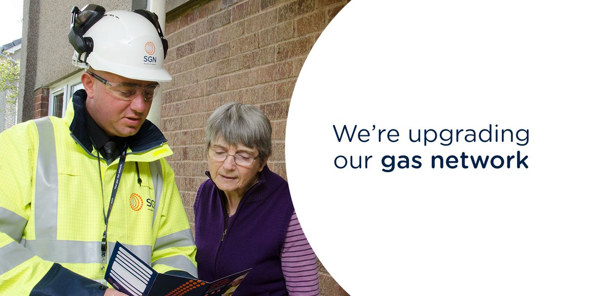 Gas engineer talking with elderly lady while reading a leaflet