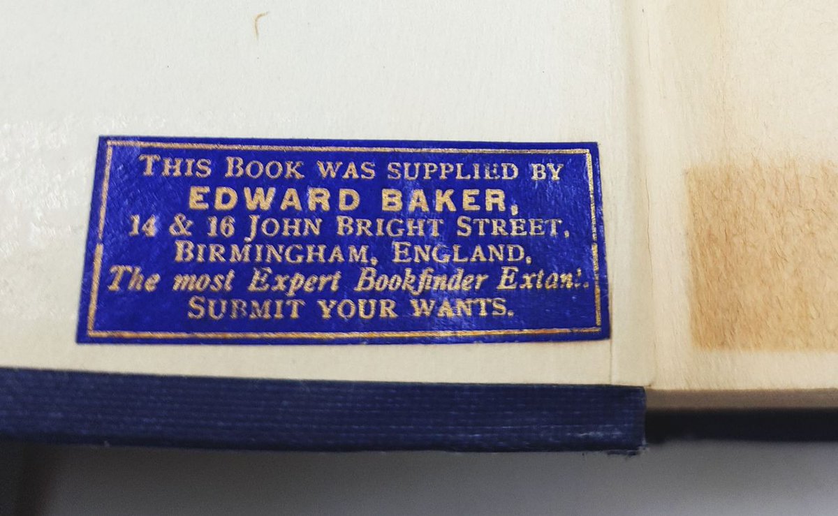 A small rectangular label in blue and gold found inside a book, it says 'this book was supplied by Edward Baker, 14 & 16 John Bright Street, Birmingham, England, the most expert bookfinder extant, submit your wants' 