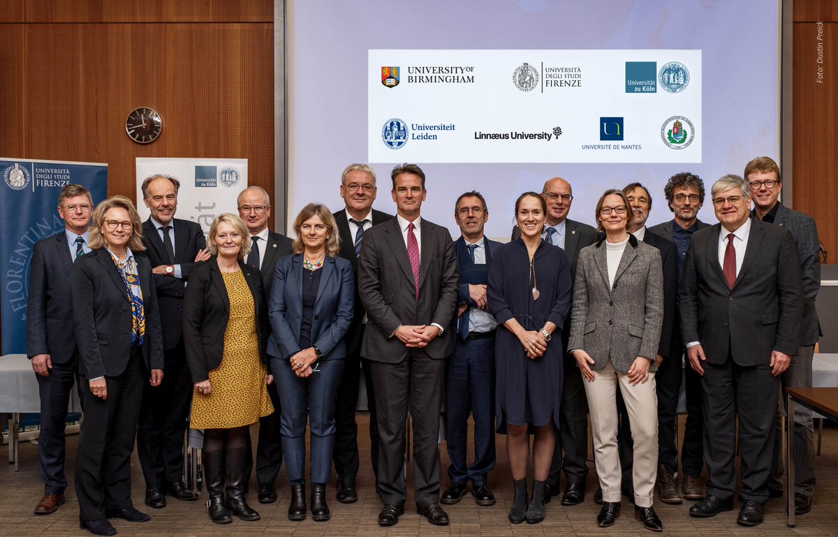 Gruppenfoto vor den sieben Universitätslogos der Universitäten Birmingham (Großbritannien), Florenz (Italien), Köln (Deutschland), Leiden (Niederlande), Linnaeus (Schweden), Nantes (Frankreich) und Semmelweis (Ungarn).
