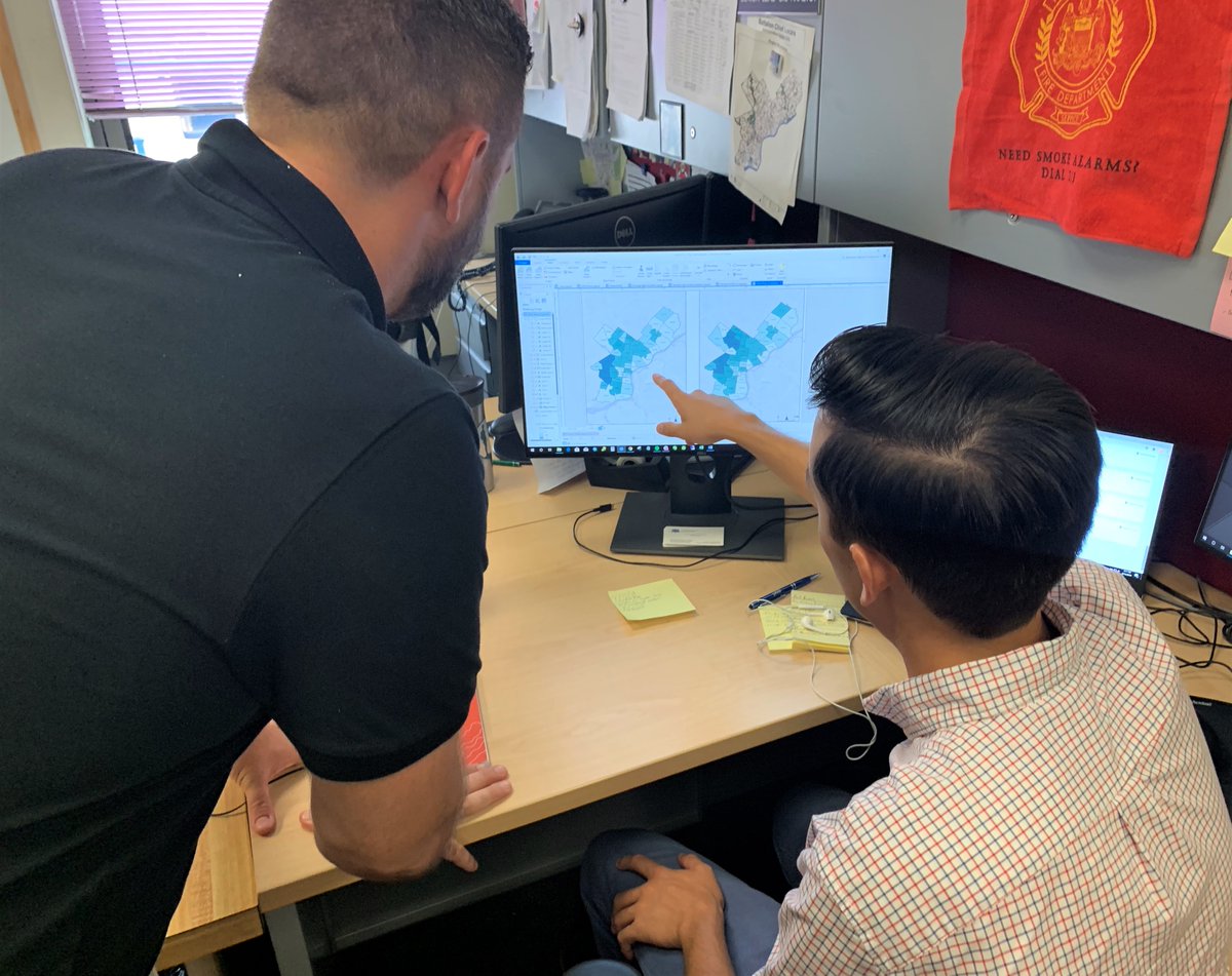 two men looking at map on computer screen with one pointing at it
