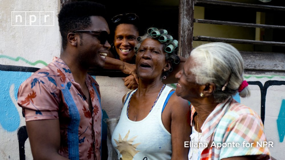 Cuban singer Erik Iglesias Rodriguez (left), who performs as Cimafunk, talks with women on the street in Havana.
