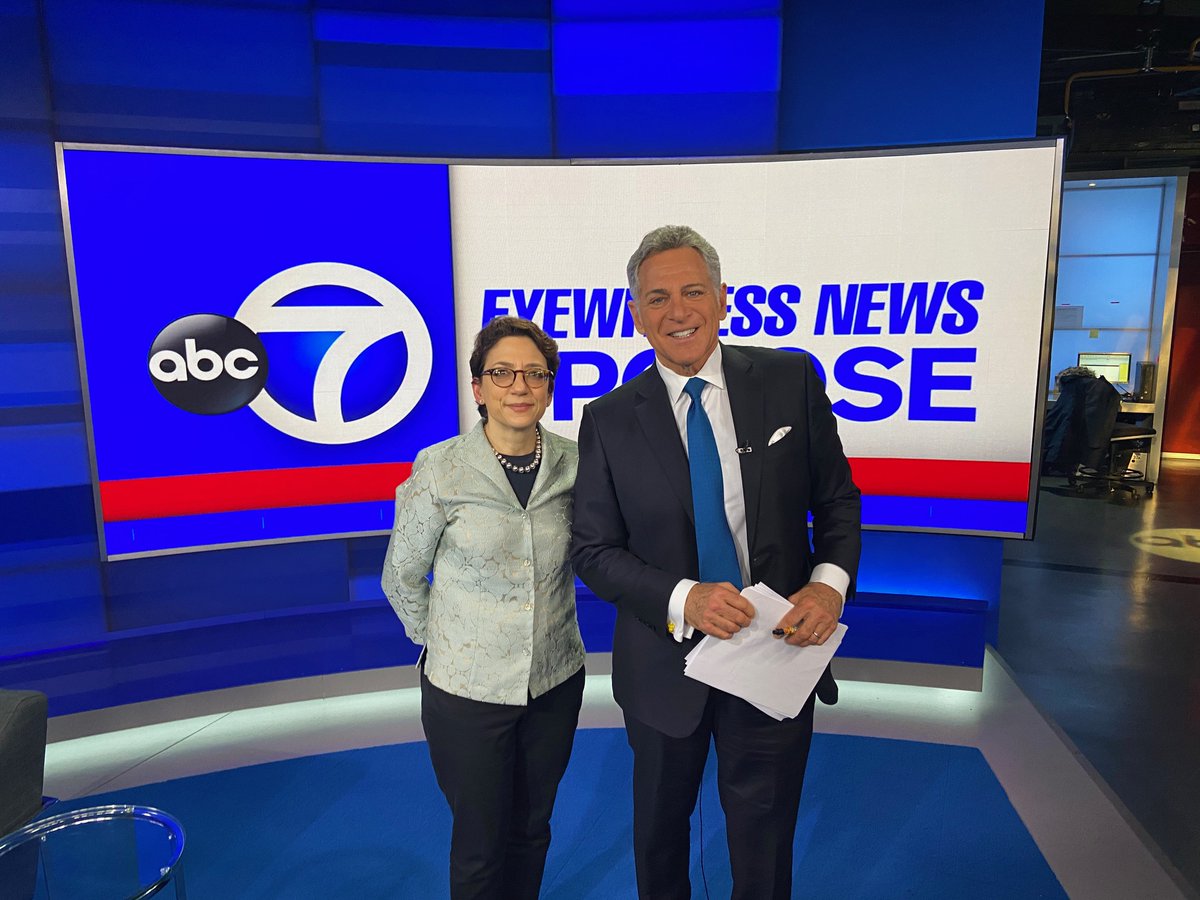 Commissioner Trottenberg and Bill Ritter pose for a photo in front of the A B C 7 logo 