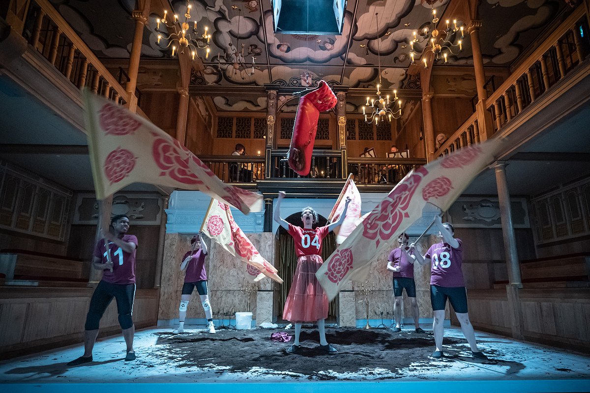 A group of people wave flags surrounding a leader.